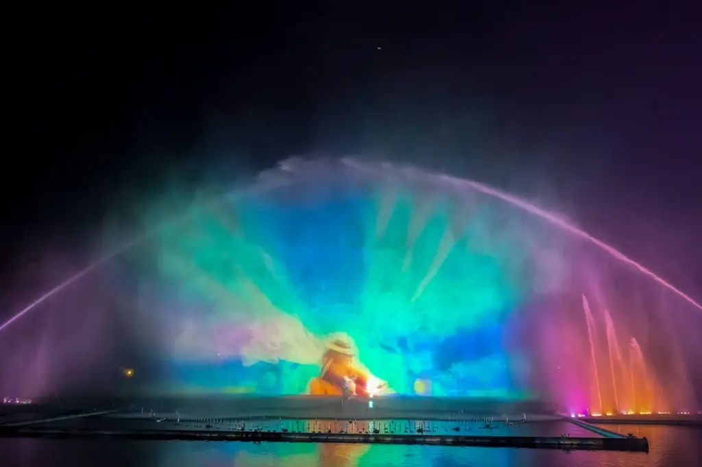Colorful fountain and laser light show at Chiang Mai Night Safari featuring vibrant water projections, rainbow lighting, and reflections on the lake at night