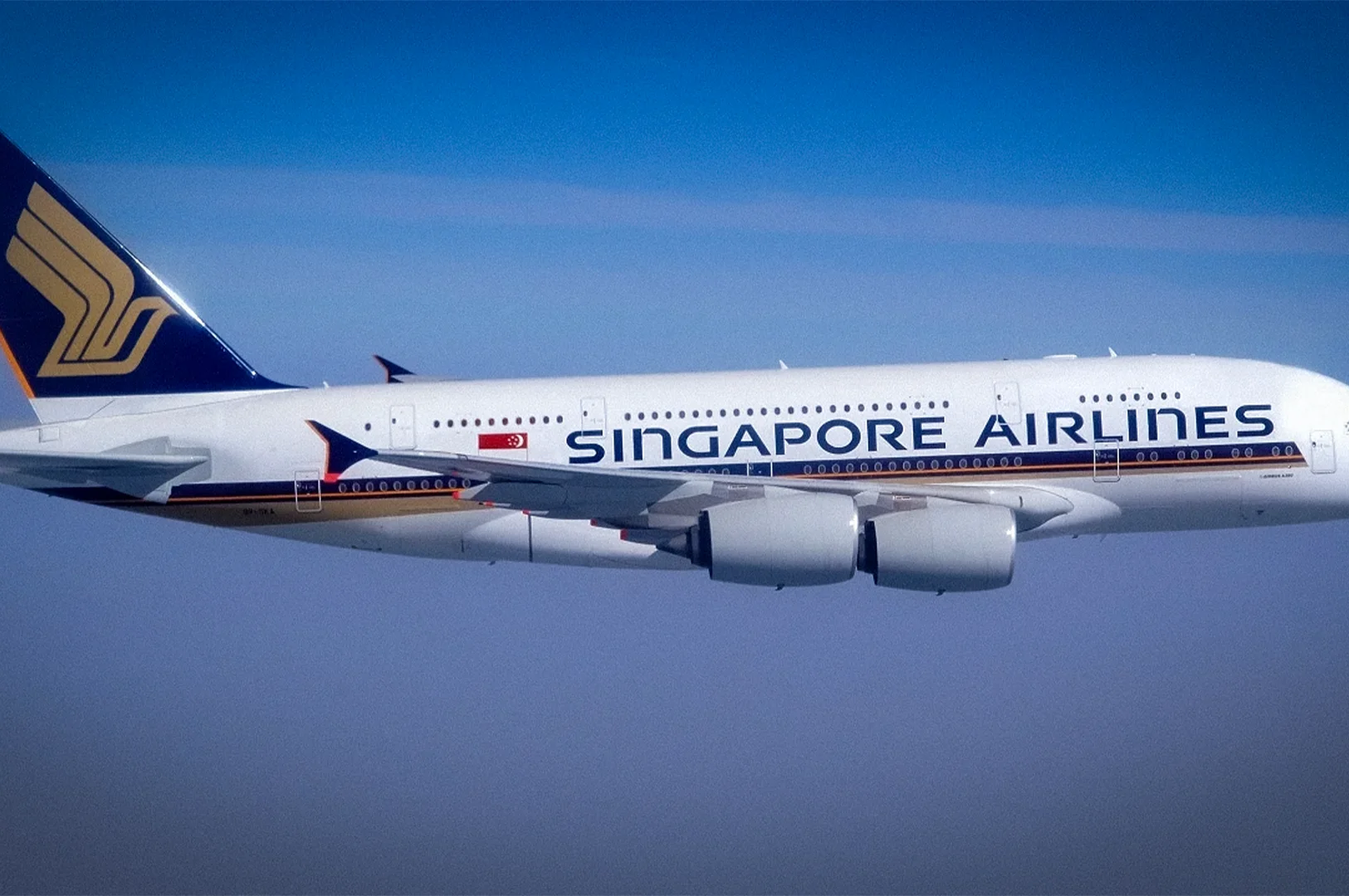 Singapore Airlines Airbus A380 passenger airplane flying in clear blue skies with the airline logo and branding visible on the aircraft fuselage and tail fin