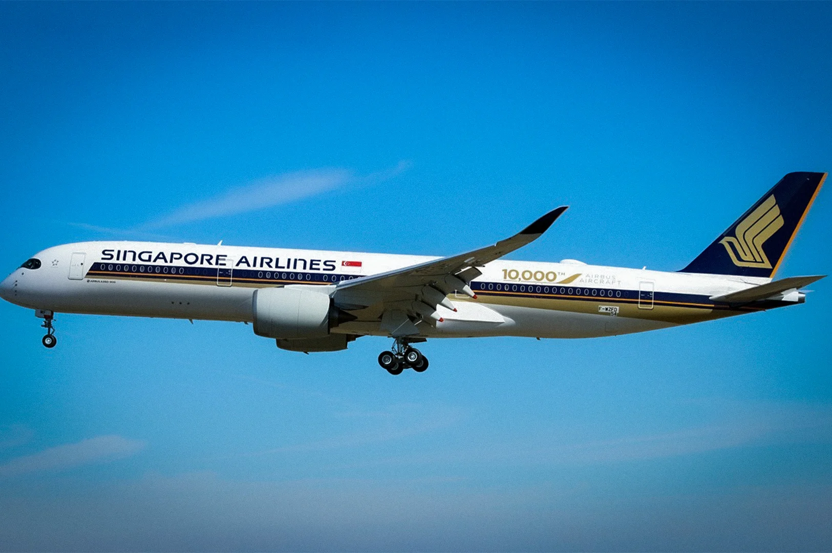 Singapore Airlines Airbus A350 passenger aircraft flying with landing gear deployed against a clear blue sky during approach for landing