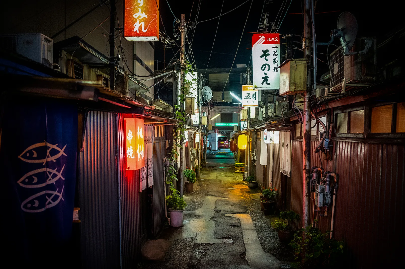 Narrow nightlife alley in Katamachi, Kanazawa, Japan, illuminated by colorful neon signs and traditional izakaya storefronts, showcasing the city's vibrant evening dining and entertainment district.