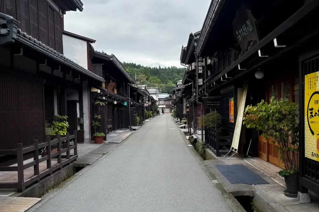 Historic Sanmachi Suji street in Takayama, Japan, lined with traditional wooden merchant houses, local shops, and preserved Edo-period architecture.