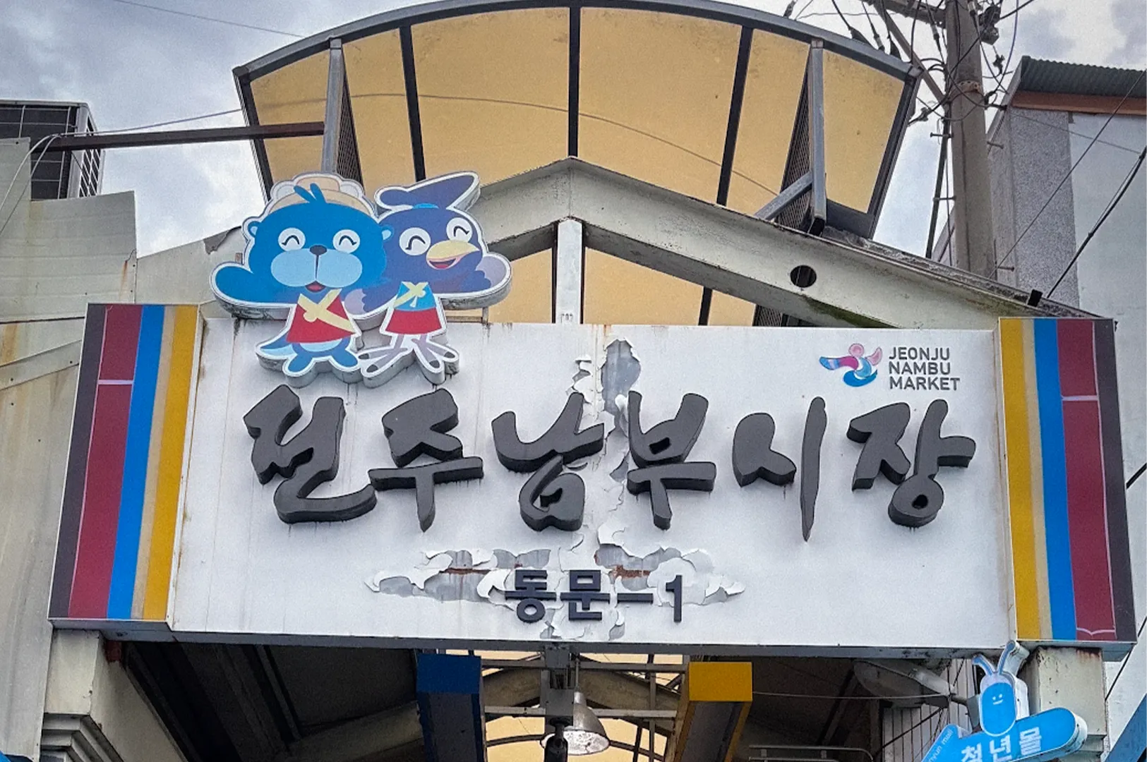 Main entrance of Jeonju Nambu Market in South Korea featuring the covered market arcade, local shops, storefront signage and traditional market atmosphere.