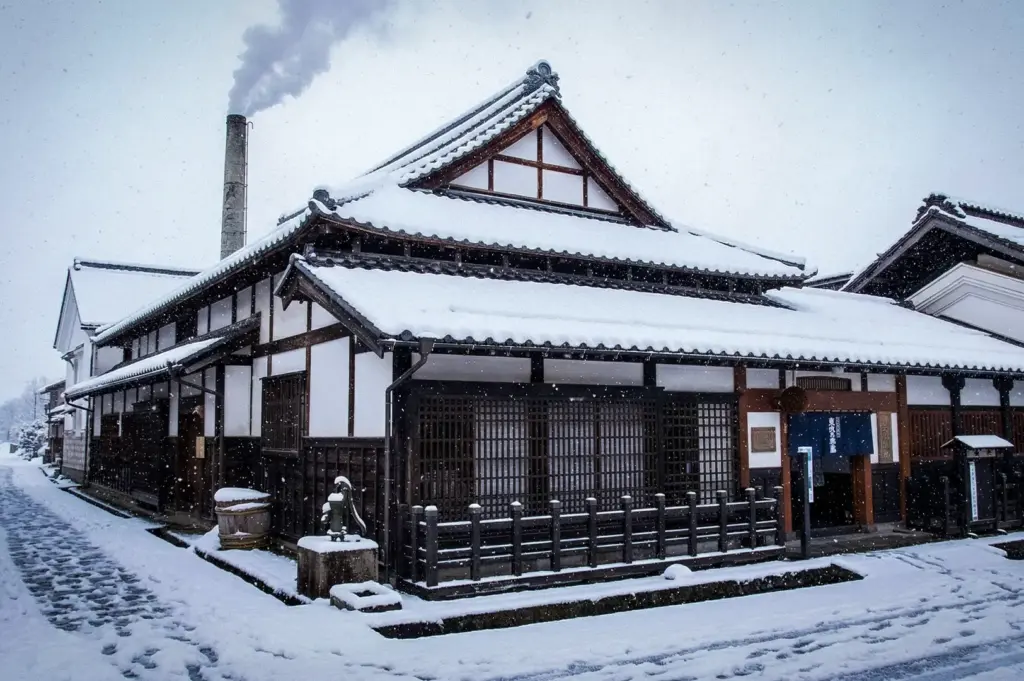 Traditional Japanese building in Takayama, Japan, blanketed in snow along a quiet historic street, showcasing preserved architecture and a picturesque winter atmosphere.