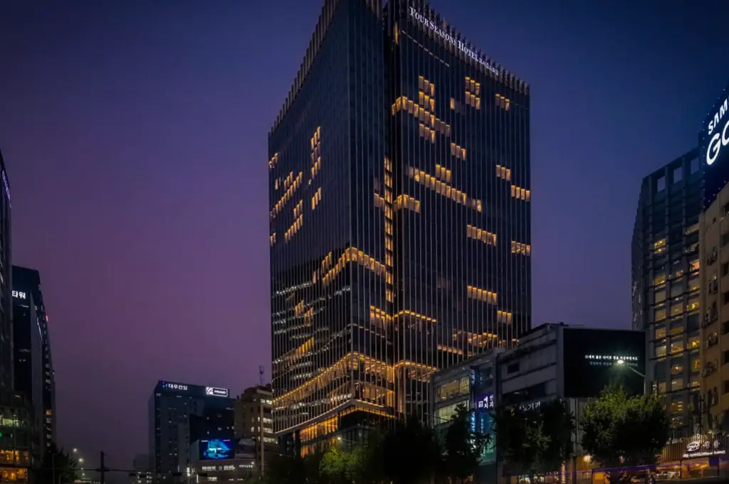 Four Seasons Hotel Seoul illuminated at night in the heart of Seoul's business district, showcasing its modern luxury architecture and vibrant city skyline.