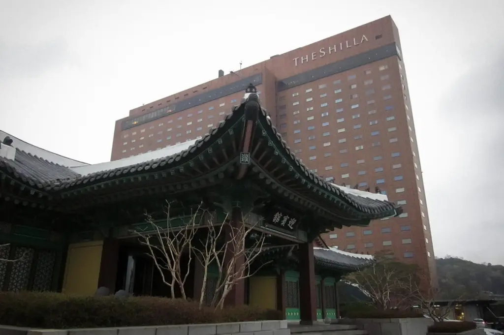 The Shilla Seoul hotel exterior with traditional Korean hanok architecture in the foreground, blending modern luxury with Korean cultural heritage.