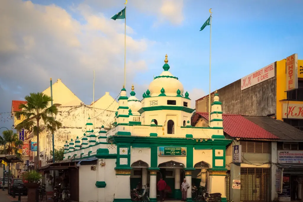 Nagore Durgha Sheriff Mosque in Penang, Malaysia, featuring its distinctive green-and-white facade along a historic street in George Town.