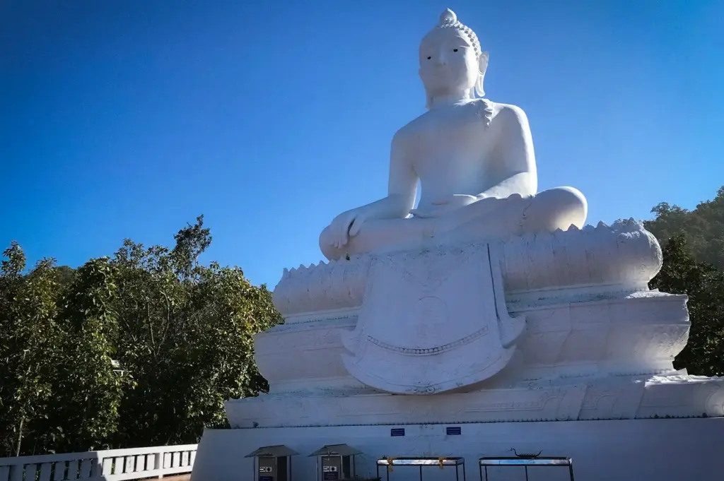 Wat Phra That Mae Yen in Pai, Thailand featuring the iconic giant white Buddha statue overlooking the surrounding mountains and lush countryside.