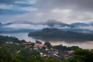 Luang Prabang Laos with the Mekong River, misty mountains, and traditional rooftops at sunrise