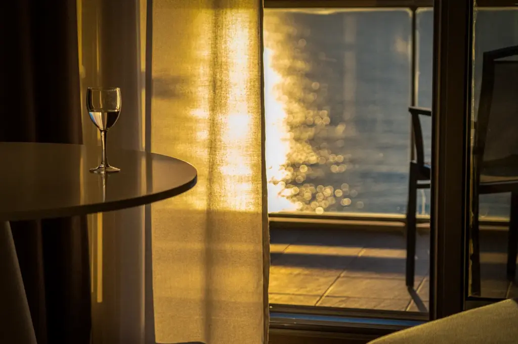 Warm hotel room interior overlooking a sunlit beach and ocean view