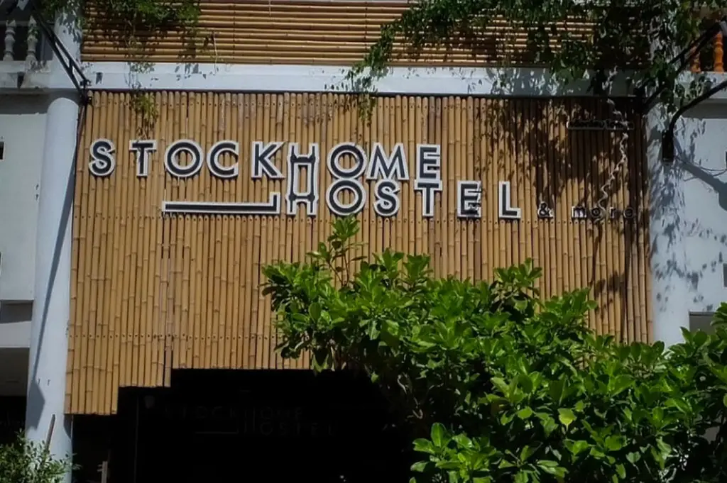 Front entrance of Stockhome Hostel Ayutthaya in Ayutthaya, Thailand, featuring a bamboo-style facade, outdoor seating, bicycles, and a convenient location near the historic city center.