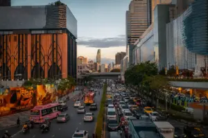 Bangkok Thailand cityscape with busy traffic, modern shopping malls, and urban skyline at sunset
