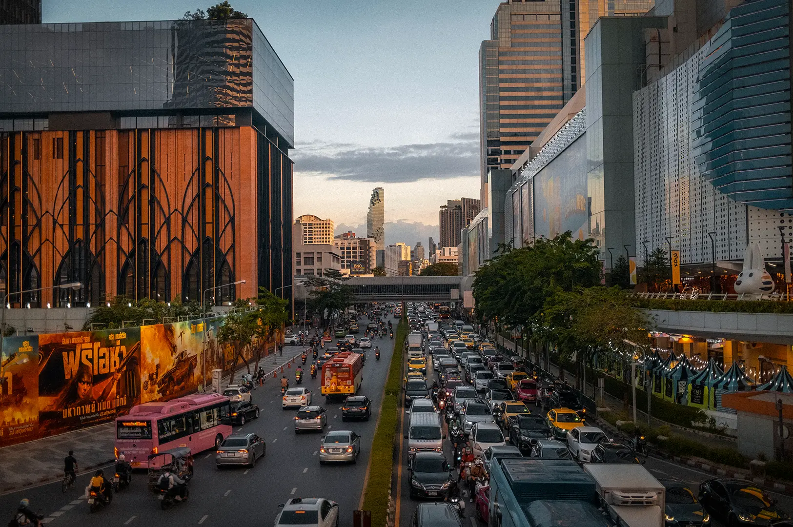 Bangkok Thailand cityscape with busy traffic, modern shopping malls, and urban skyline at sunset