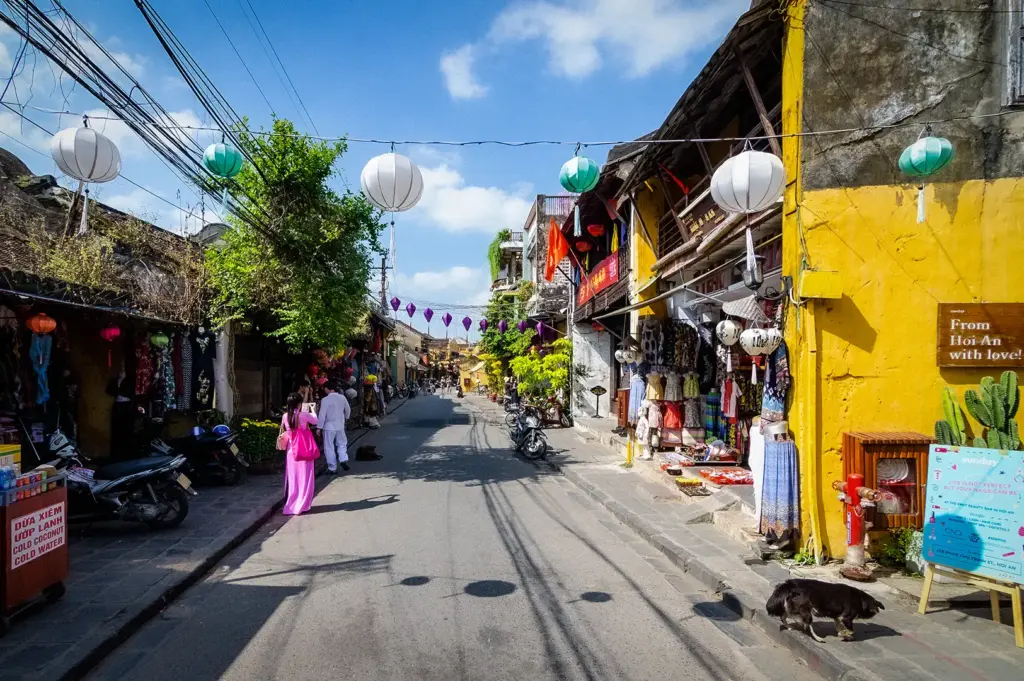 Hoi An Ancient Town in Vietnam with colorful lanterns, historic yellow buildings, local shops, traditional architecture, and a lively street scene.