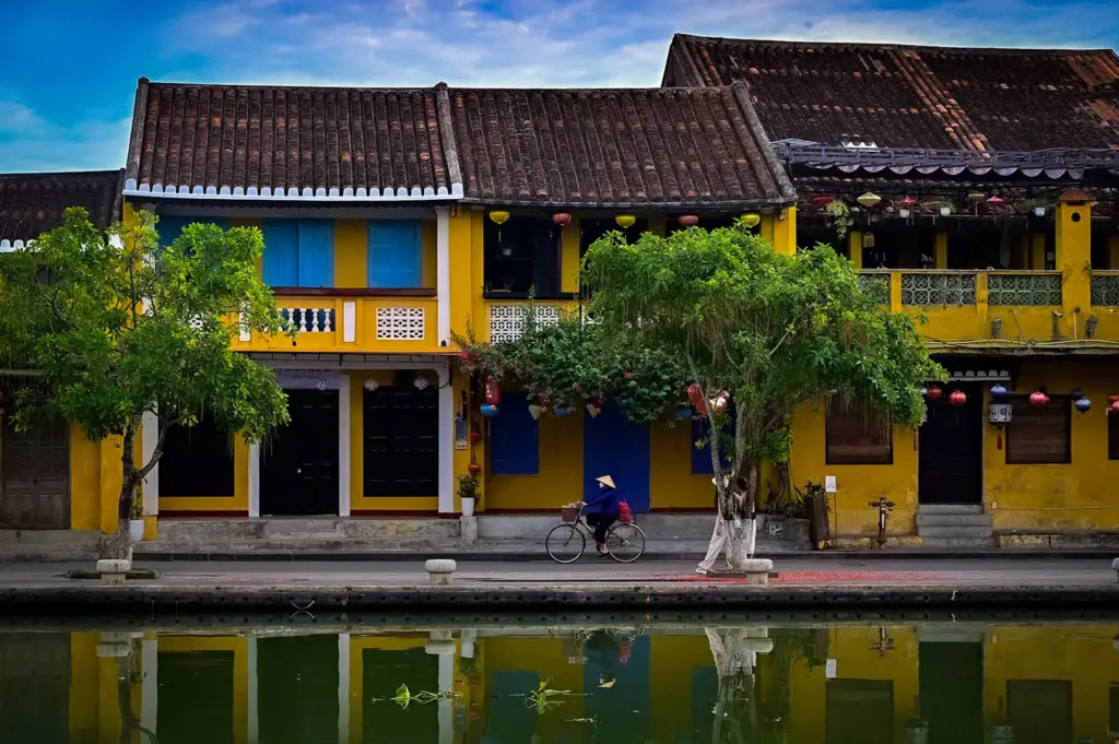 Traditional yellow buildings with tiled roofs reflected in the water of Hoi An Ancient Town in Vietnam