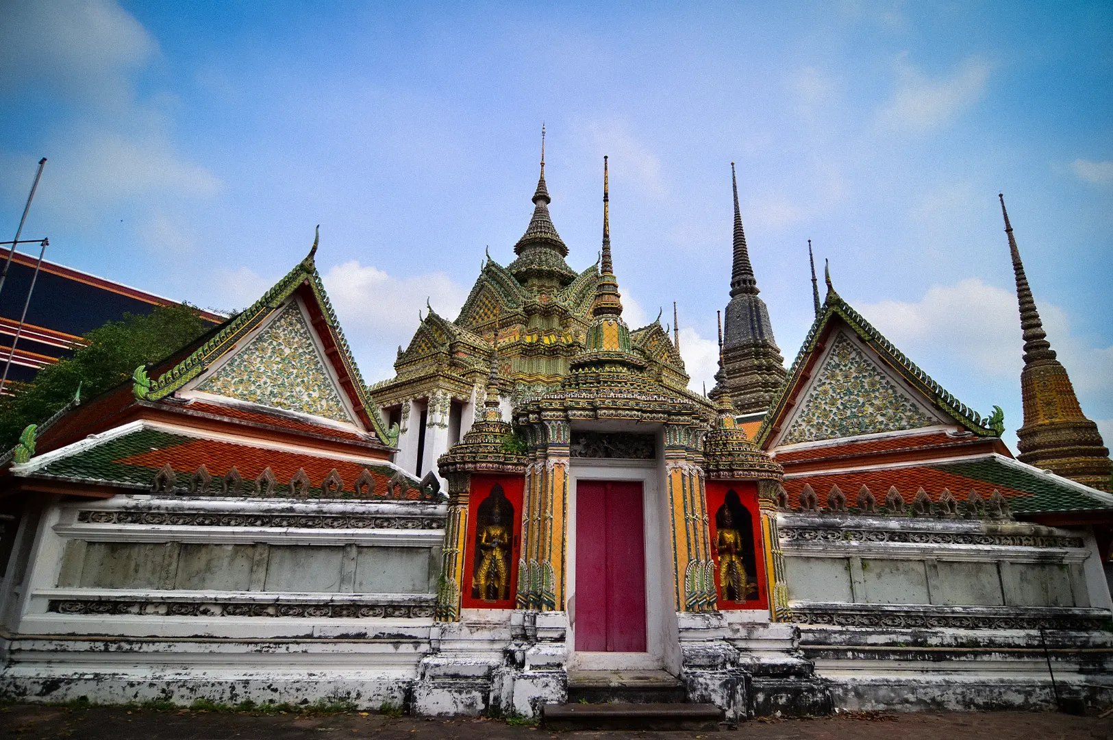 Wat Pho Bangkok temple architecture with ornate Thai roof, colorful decorations, and intricate spires