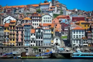 Scenic view of colorful historic buildings and traditional boats along the Douro River waterfront in Porto, Portugal